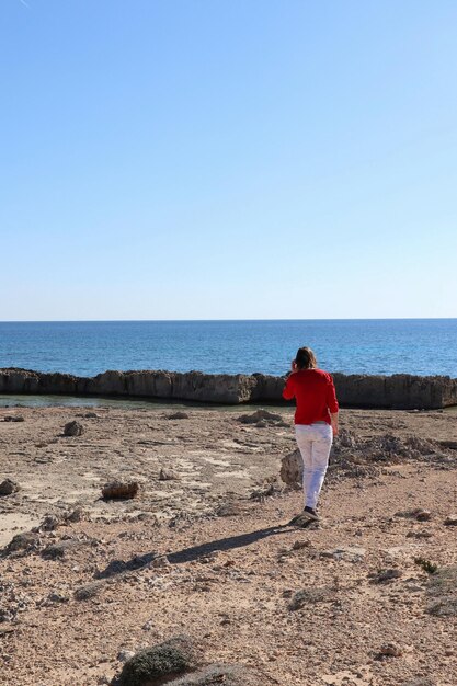 Photo rear view of man on beach against clear sky