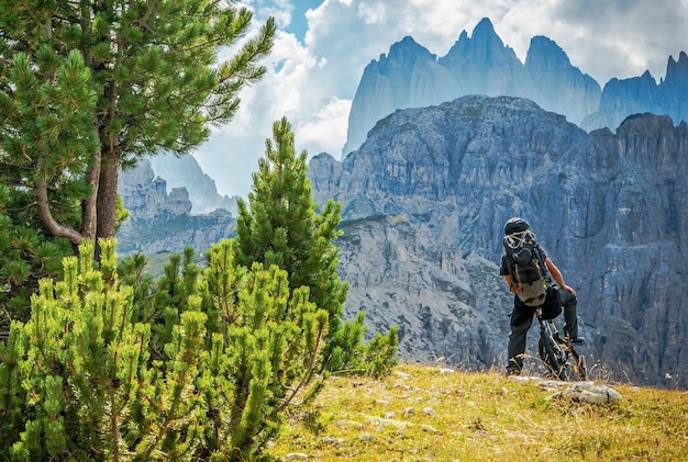 Foto vista posteriore di un uomo in bicicletta contro le montagne