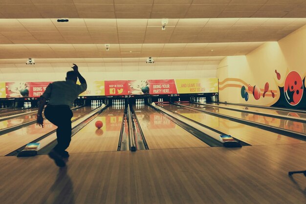 Rear view of man in bowling alley