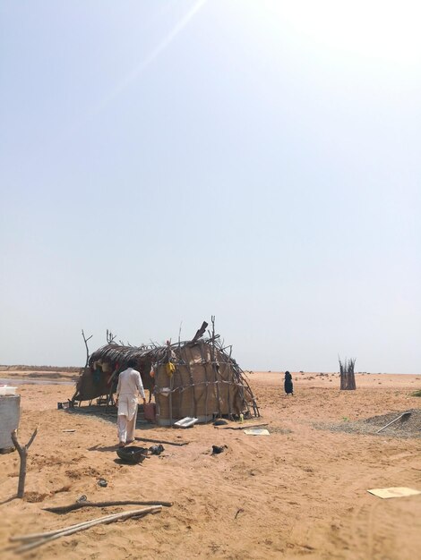 Photo rear view of man by hut at desert