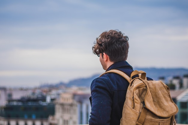 Rear view of man in city against sky