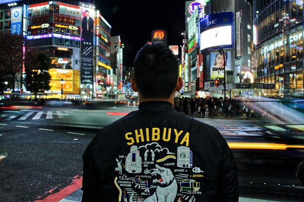 Foto vista posteriore di un uomo in una strada della città di notte