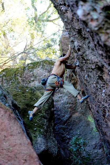 Foto vista posteriore di un uomo che si arrampica su una roccia