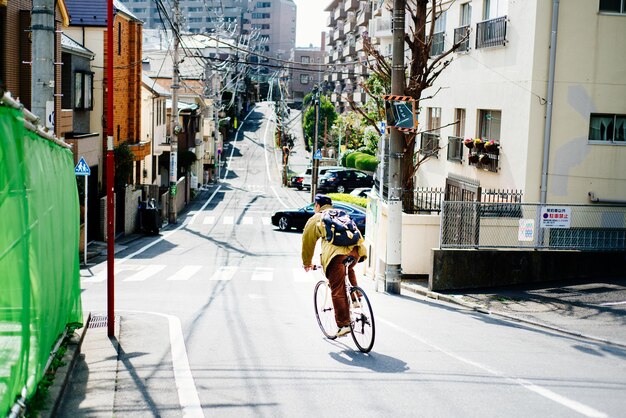 Photo rear view of man cycling on street in city