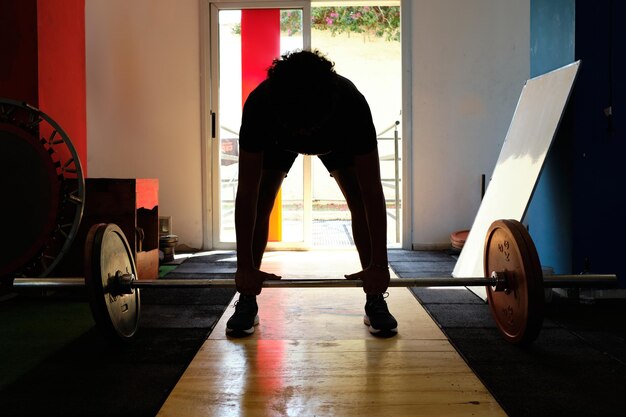 Photo rear view of man exercising at gym