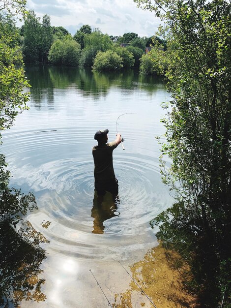 Foto vista posteriore di un uomo che pesca nel lago