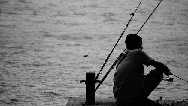 Photo rear view of man fishing in sea