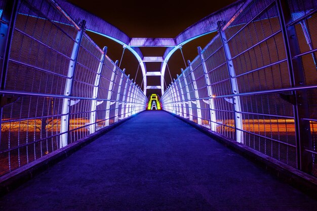 Foto vista posteriore di un uomo sul ponte pedonale di notte