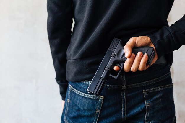 Photo rear view of man holding handgun