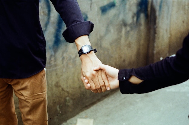 Foto vista posteriore di un uomo che si tiene per mano