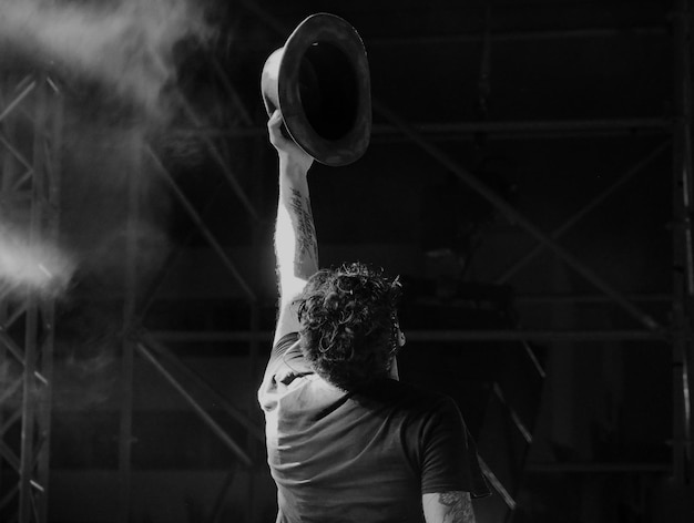 Photo rear view of man holding hat