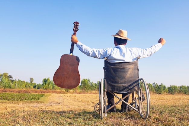 Foto vista posteriore di un uomo che tiene un ombrello sul campo contro il cielo