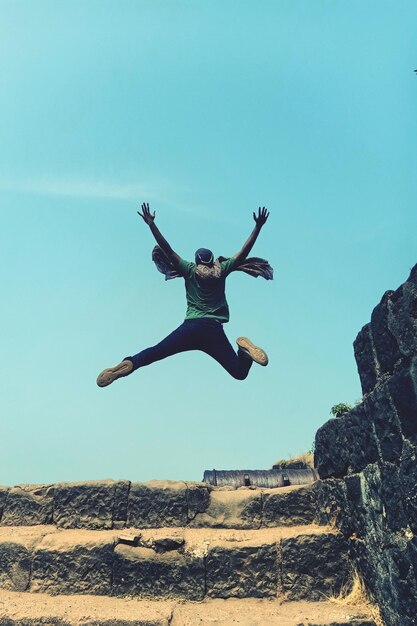 Photo rear view of man jumping against clear sky