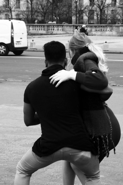 Foto vista posteriore di un uomo che solleva una donna mentre è in piedi sul sentiero