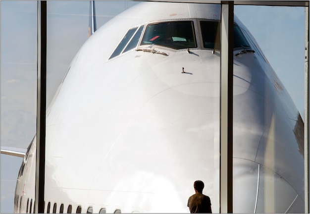 Foto vista posteriore di un uomo che guarda l'aereo attraverso la finestra