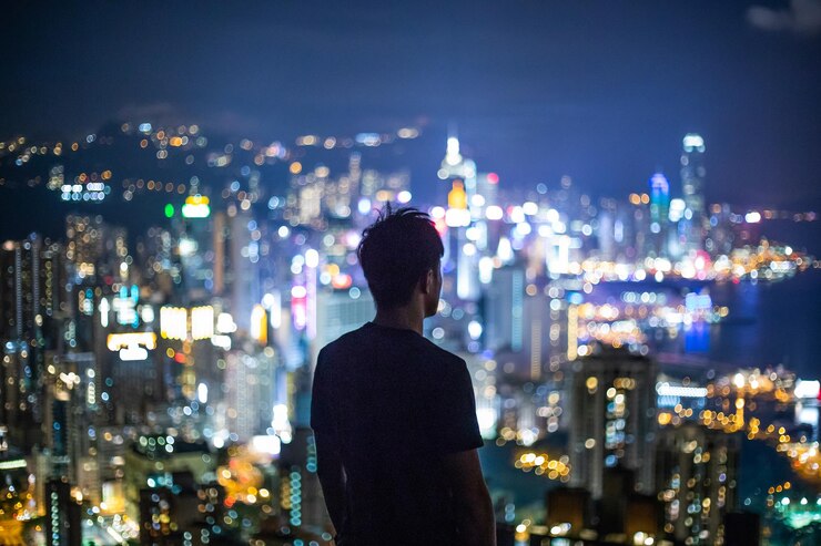 Photo 밤 에 조명 된 도시 건물 을 바라보는 사람 의 뒷면