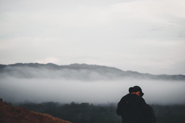 Photo rear view of man looking at mountain against sky