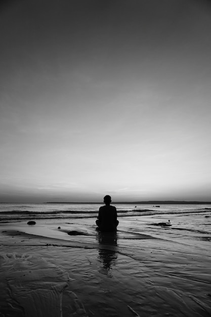 Foto vista posteriore di un uomo che guarda il mare contro il cielo