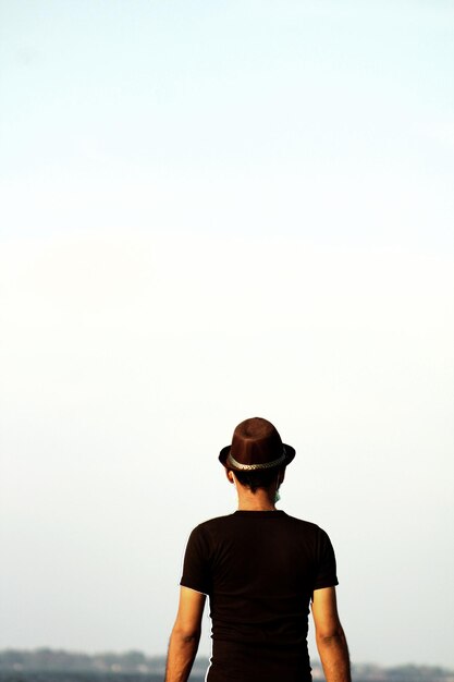 Foto vista posteriore di un uomo che guarda il mare contro il cielo