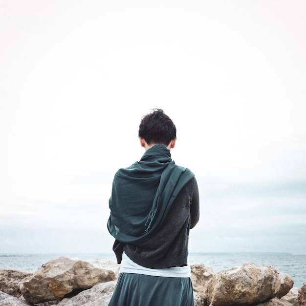 하늘 을 배경 으로 바다 를 바라보는 사람 의 뒷면