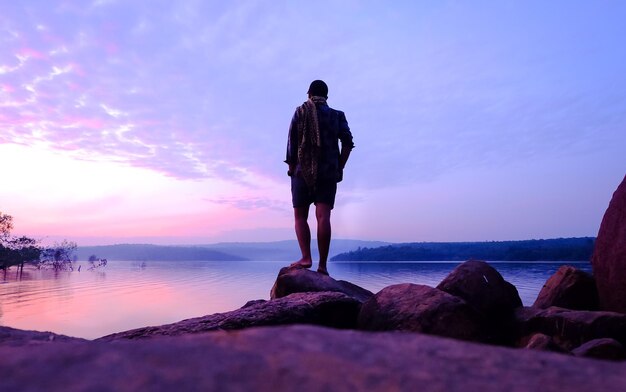 Rear view of man looking at sea against sky