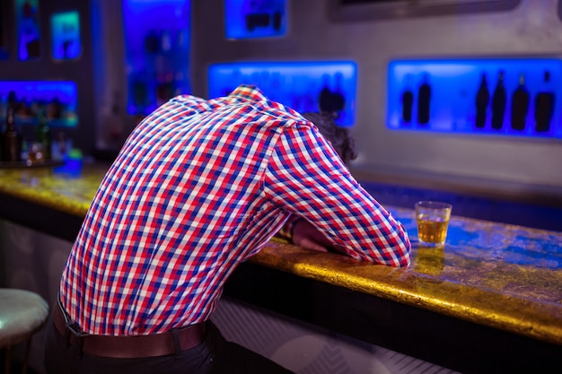 Rear view of man lying on bar counter