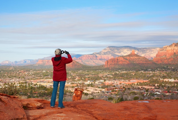 Rear view of man photographing against sky