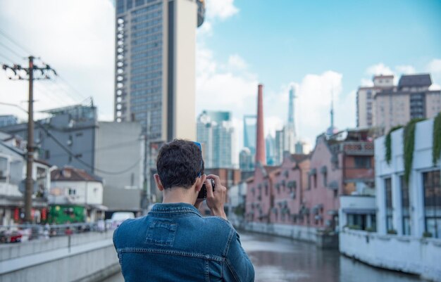 都市風景を撮影している男の後ろの景色