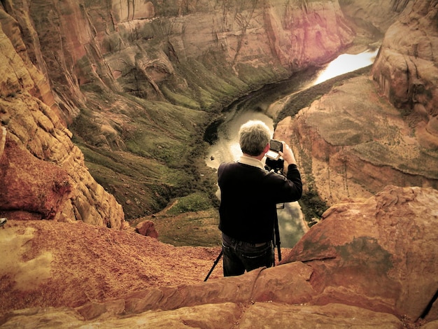 Photo rear view of man photographing at horseshoe bend