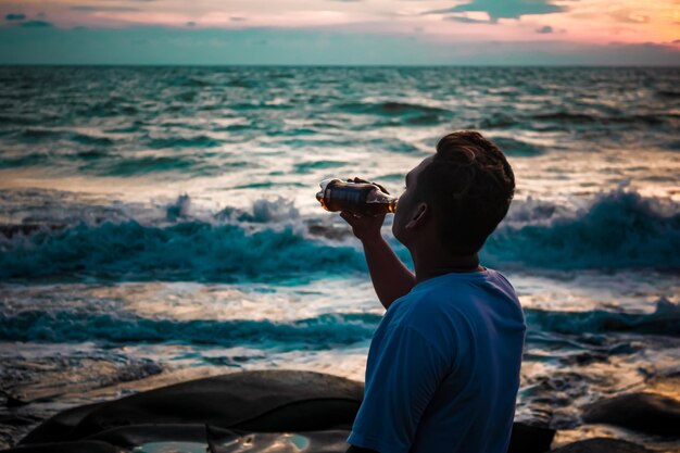 Photo rear view of man photographing sea