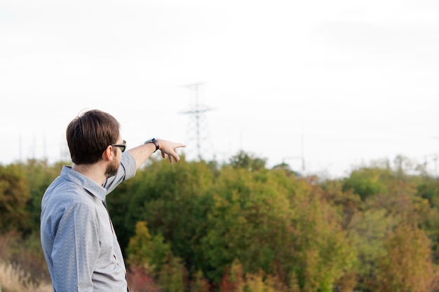 Photo rear view of a man pointing over open countryside