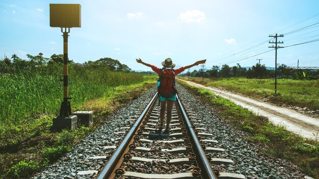 Rear view of man on railroad tracks against sky