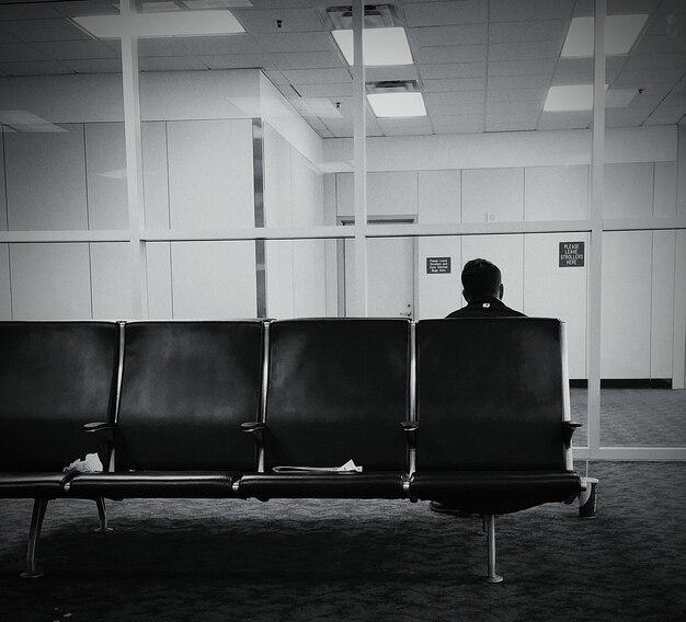 Foto vista posteriore di un uomo che si rilassa sul sedile nella sala d'attesa