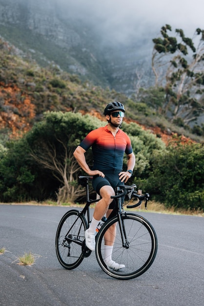 Photo rear view of man riding bicycle on road