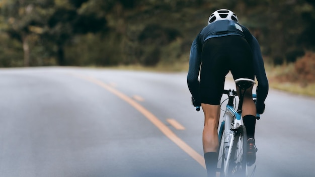 Photo rear view of man riding bicycle on road