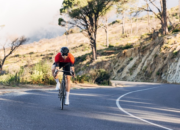 Photo rear view of man riding bicycle on road