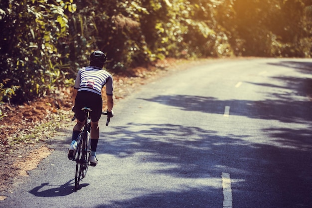 道路で自転車に乗っている男の後ろの景色