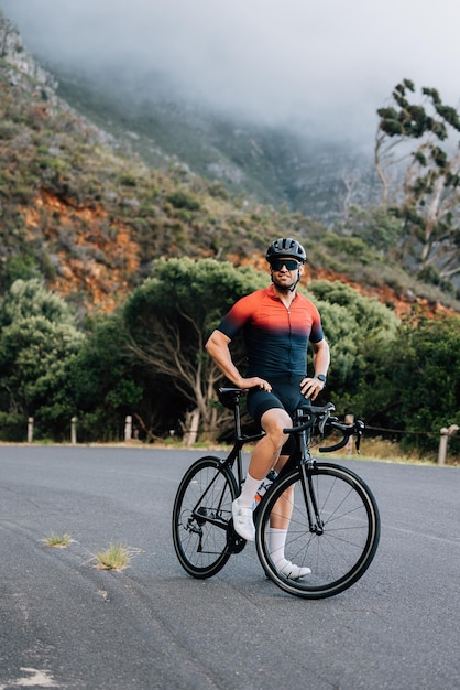 Photo rear view of man riding bicycle on road