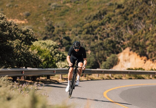 Photo rear view of man riding bicycle on road