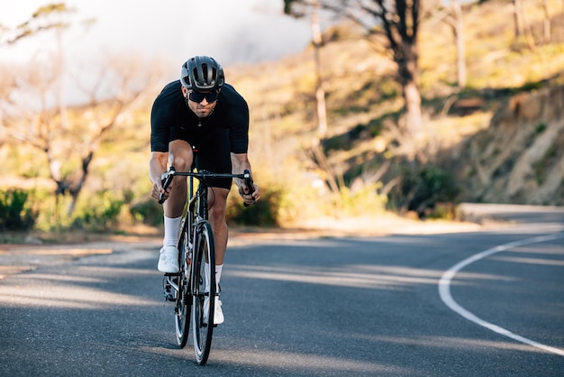 Photo rear view of man riding bicycle on road