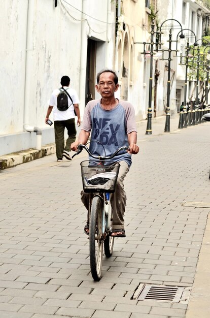 Rear view of man riding bicycle on street