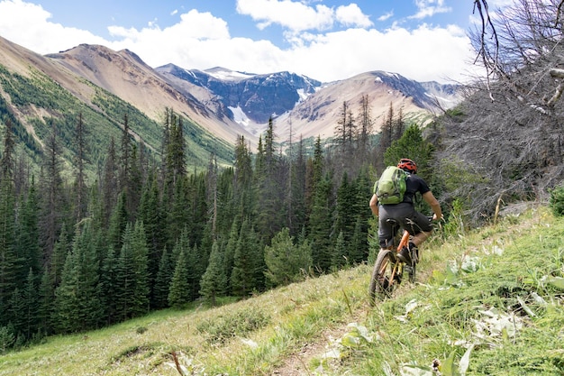 Photo rear view of man riding bike on mountain