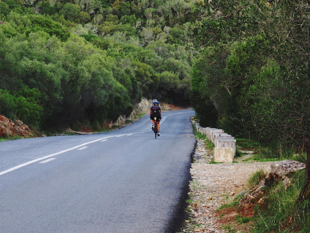 Photo rear view of man riding motorcycle on road