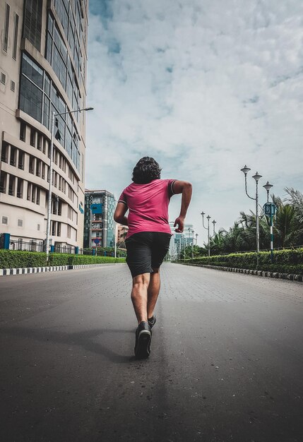 Rear view of man running on road