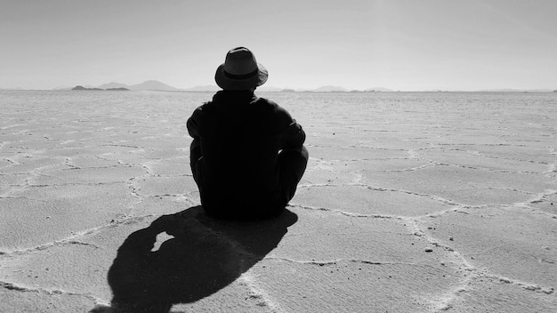 Foto la vista posteriore dell'uomo al salar de uyuni in una giornata di sole