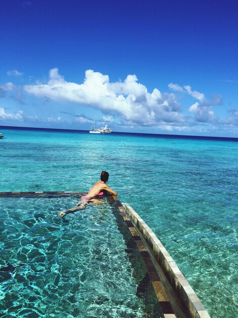 Foto vista posteriore di un uomo in mare contro il cielo