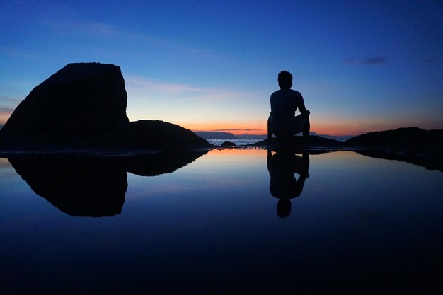 Photo rear view of man on seashore during sunset