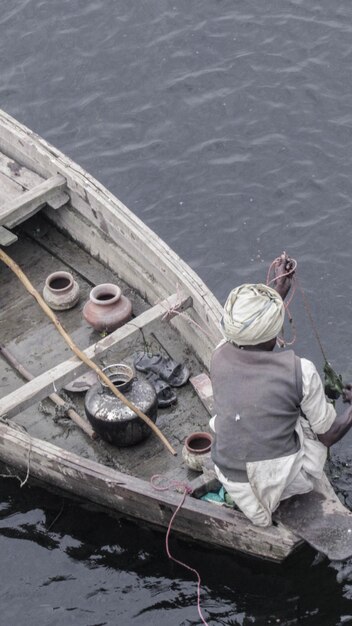 Photo rear view of man sitting in boat on lake