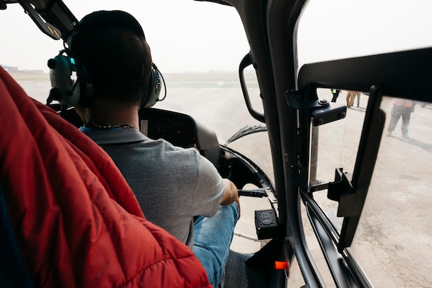 Photo rear view of man sitting in helicopter