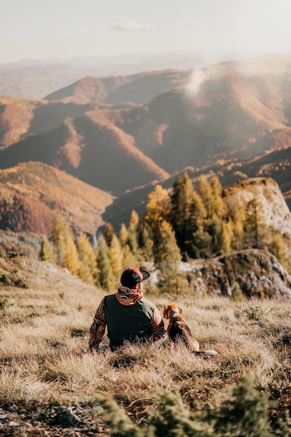 Foto vista posteriore di un uomo seduto sulla montagna